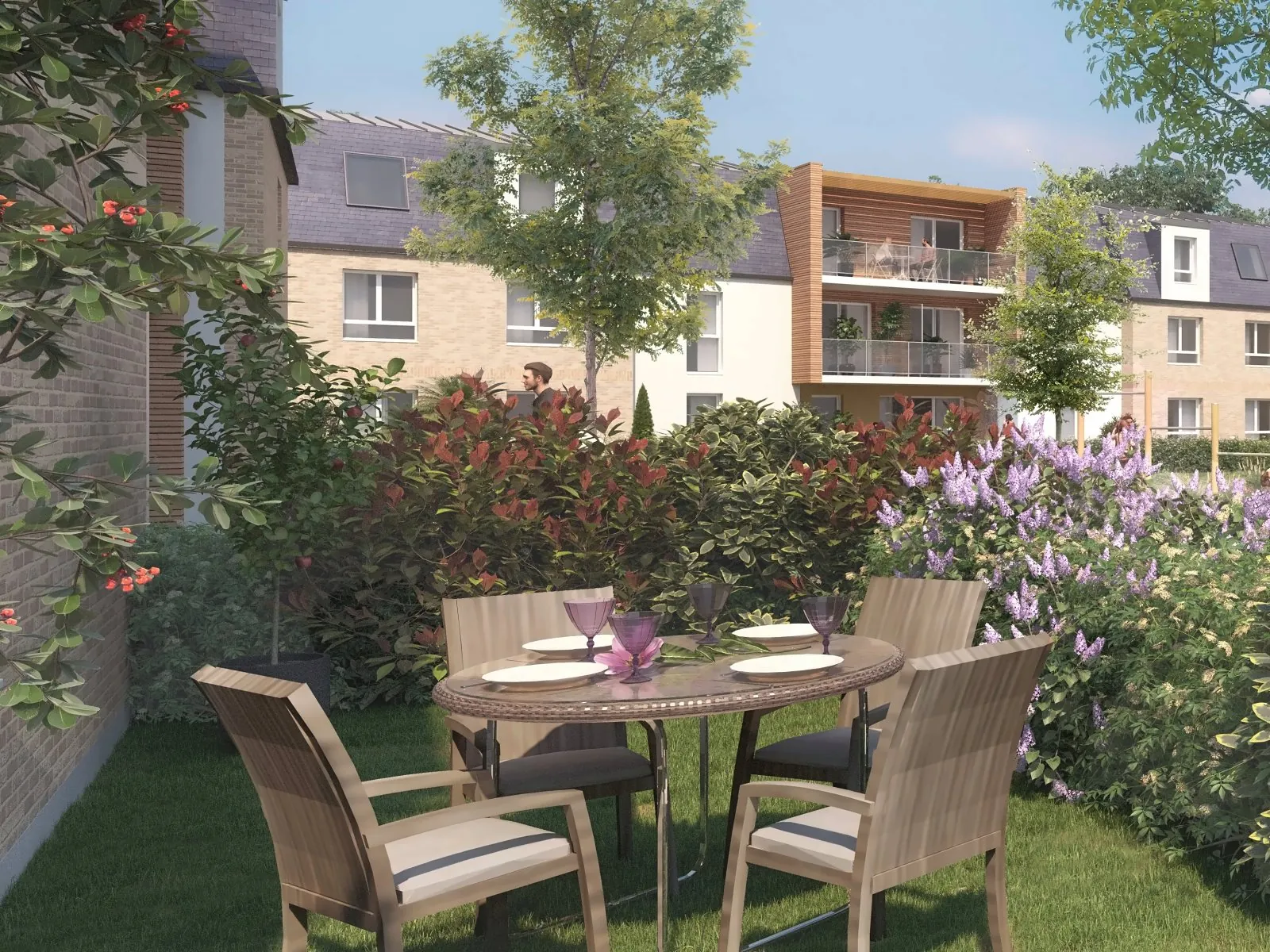 Un jardin privatif en rez-de-chaussée : une table et ses fauteuils sur la pelouse, des lilas, une haie fleurie, et la résidence derrière